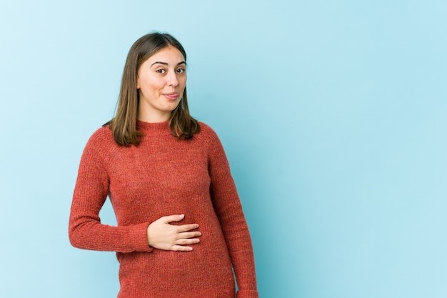 Jeune femme touche le ventre, sourit doucement, concept de manger et de satisfaction