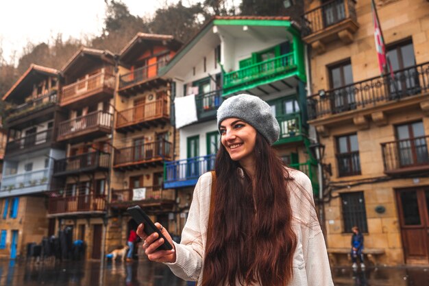 Jeune femme de tourisme caucasien utilisant le smartphone dans une vieille ville.