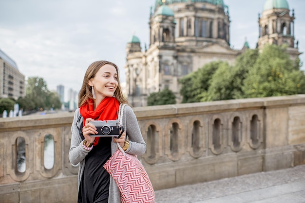 Jeune femme touriste avec appareil photo profitant de voyager dans la ville de Berlin marchant sur le vieux pont près de la célèbre cathédrale