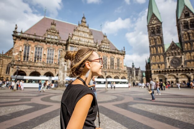 Jeune femme touriste bénéficiant d'une vue magnifique sur le bâtiment de l'hôtel de ville et l'église dans le centre de Brême, Hambourg