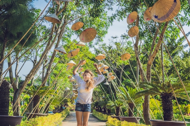 Jeune femme touriste et chapeaux vietnamiens