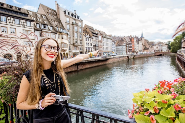 Jeune femme touriste debout avec appareil photo sur le vieux pont au-dessus du canal d'eau voyageant dans la ville de Strasbourg, France