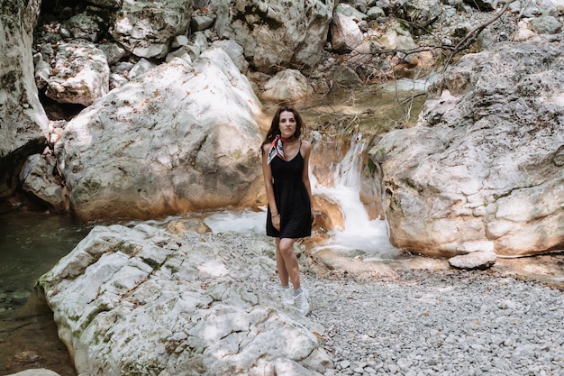 Une jeune femme touriste escalade les montagnes le long du chemin Loisirs actifs