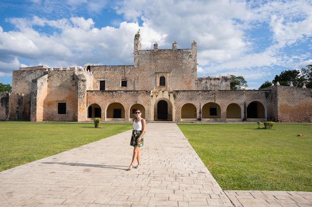 Jeune femme touriste à l'extérieur du couvent de San Bernardino avec la pelouse verte bien entretenue à Valladolid au Mexique