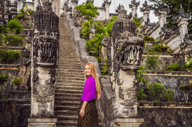 Photo jeune femme touriste sur fond de trois échelles de pierre dans le magnifique temple pura lempuyang luhur