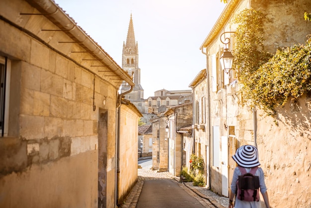 Jeune femme touriste marchant dans la vieille rue du célèbre village de Saint Emilion dans la région de Bordeaux en France