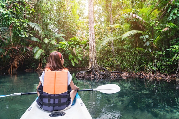 Jeune femme touriste pagayer le kayak à la racine de klong à Krabi, Thaïlande