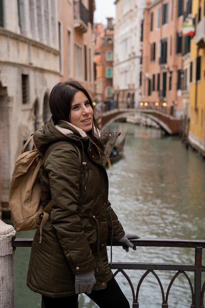 Jeune femme touriste sur un pont-canal de Venise au milieu de façades colorées