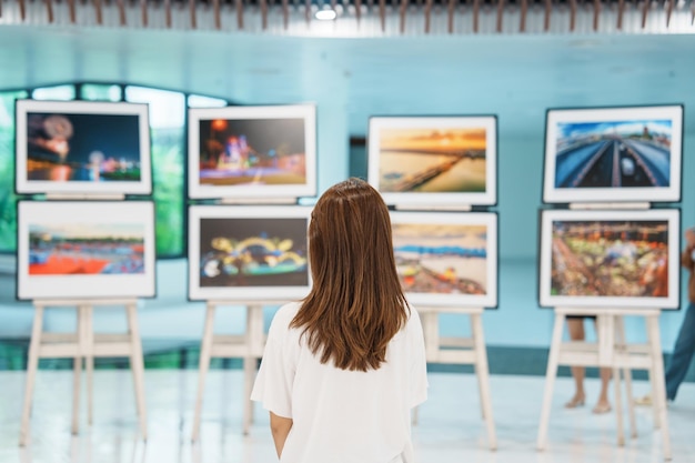 Jeune femme touriste à la recherche d'une exposition de galerie Photographie d'art et concept de musée