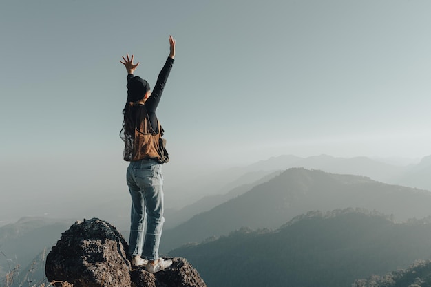 Jeune femme touriste transportant des bagages au coucher du soleil