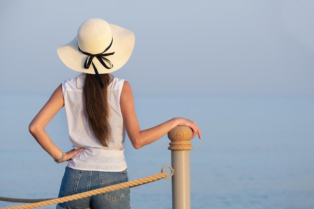 Jeune femme touriste en vêtements décontractés profitant d'une chaude journée ensoleillée au bord de la mer. Vacances d'été et concept de voyage.