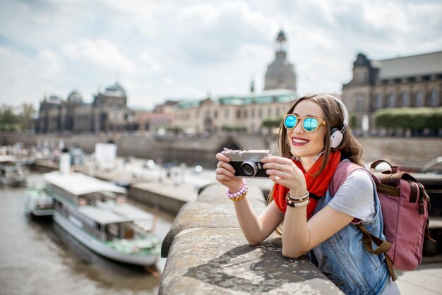 Jeune femme touristique avec appareil photo bénéficiant d'une vue magnifique depuis le pont sur la vieille ville de Dresde en Allemagne