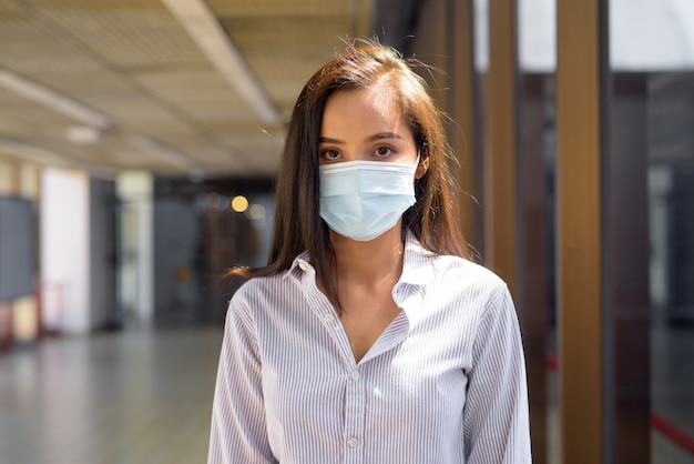 Jeune femme touristique asiatique avec masque de protection contre l'épidémie de virus corona à l'aéroport