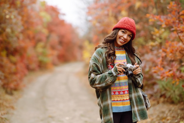 Jeune femme touristique prenant des photos dans la forêt d'automne Reste détente tourisme style de vie concept