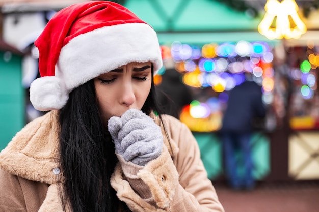 Jeune femme toussant au marché équitable d'hiver