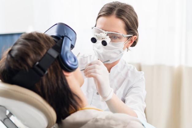 Photo une jeune femme sur un traitement dentaire moderne, utilisant des lunettes vr pour la distraire des procédures dentaires désagréables.