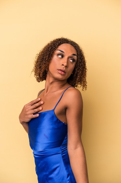 Jeune femme transsexuelle latine isolée sur fond jaune