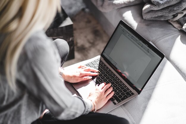 une jeune femme travaillant avec une application d'écriture sur son ordinateur portable