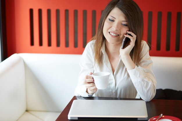 Jeune femme travaillant au café