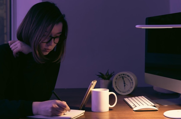 Une jeune femme travaillant la nuit sur le lieu de travail