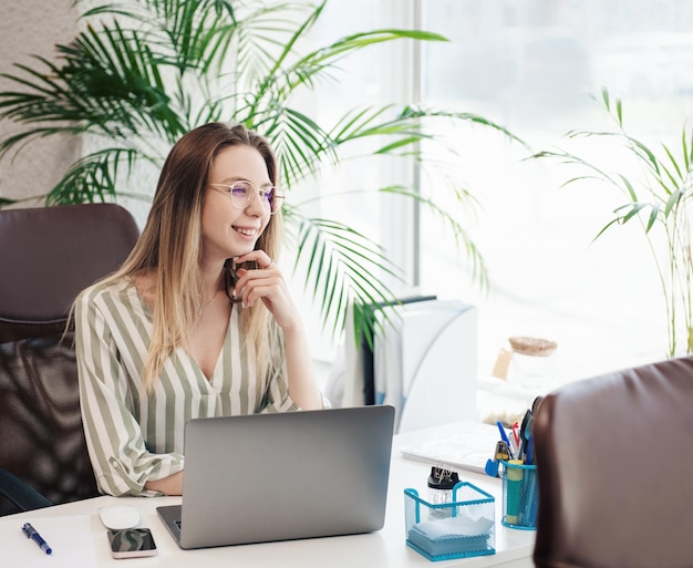 Jeune femme travaillant sur un ordinateur dans son bureau