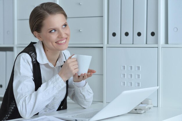 Jeune femme travaillant avec un ordinateur portable au bureau