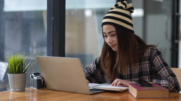 Jeune femme travaillant sur un ordinateur portable à un bureau