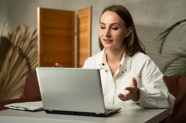 Jeune femme travaillant sur un ordinateur portable à la maison travail à la maison vidéo conférence vidéo appel en ligne