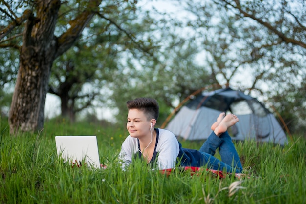 Jeune femme travaillant sur son ordinateur portable dans le parc