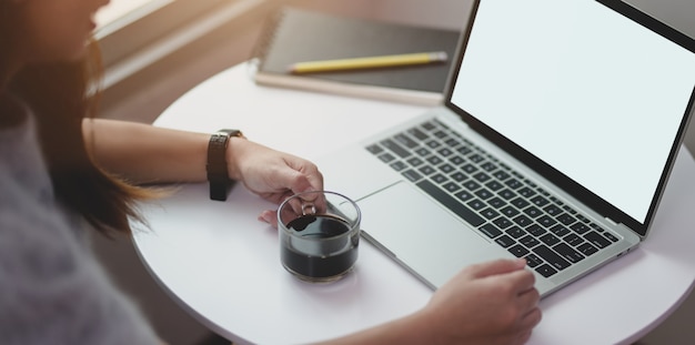 Jeune femme travaillant sur son projet en buvant une tasse de café