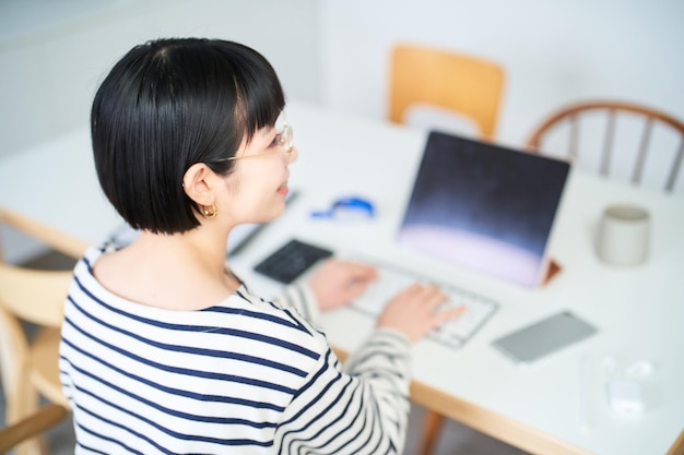 Jeune femme travaillant à table dans la chambre