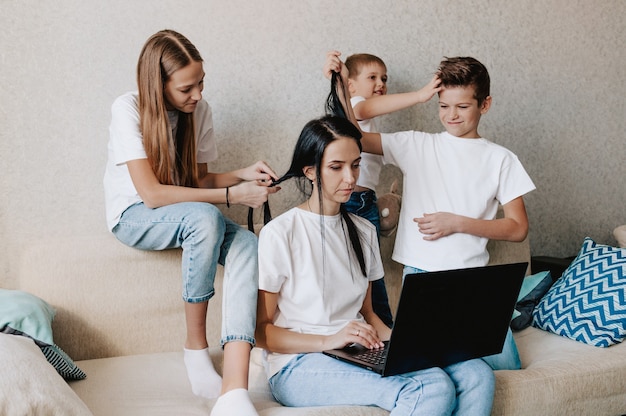 Une Jeune Femme Travaille à La Maison Avec Un Ordinateur Portable Avec Les Enfants Les Enfants Veulent Communiquer Avec Leur Mère Faire Du Bruit Et Interférer Avec Le Travail