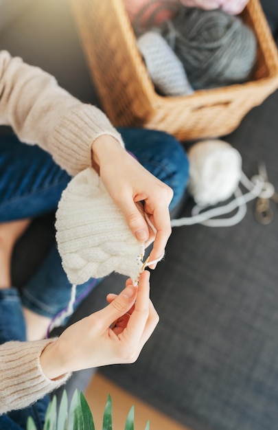 Jeune femme tricotant une écharpe chaude à l'intérieur