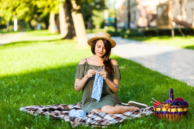 Jeune femme tricotant Oudoors dans le parc