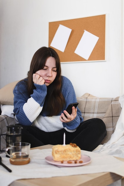 Une jeune femme triste a appuyé sa joue sur sa main et regarde l'espace de copie d'écran de téléphone portable