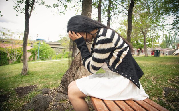 Jeune femme triste et déprimée dans le parc