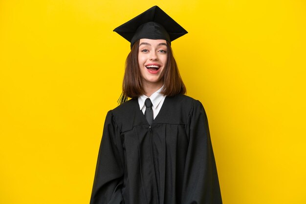 Jeune femme ukrainienne diplômée universitaire isolée sur fond jaune avec une expression faciale surprise