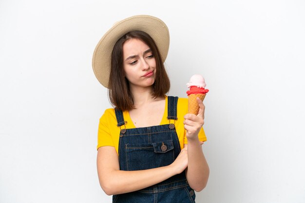 Jeune femme ukrainienne avec une glace au cornet isolée sur fond blanc avec une expression triste