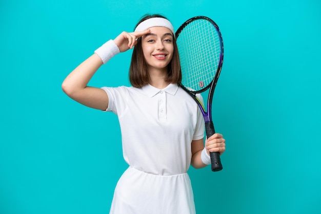 Jeune femme ukrainienne isolée sur fond bleu jouant au tennis