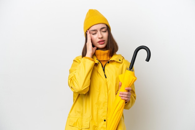 Jeune femme ukrainienne avec manteau imperméable et parapluie isolé sur fond blanc avec maux de tête