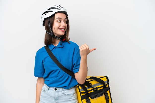 Jeune femme ukrainienne avec sac à dos thermique isolé sur fond blanc pointant vers le côté pour présenter un produit