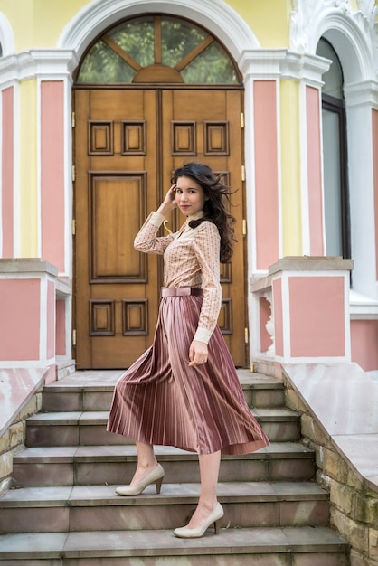 Jeune femme ukrainienne en tissu élégant près d'un bâtiment de couleur moderne dans la rue de la ville