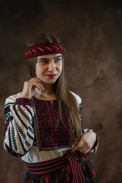 Jeune femme ukrainienne en vêtements nationaux vyshyvanka et un foulard pose en studio