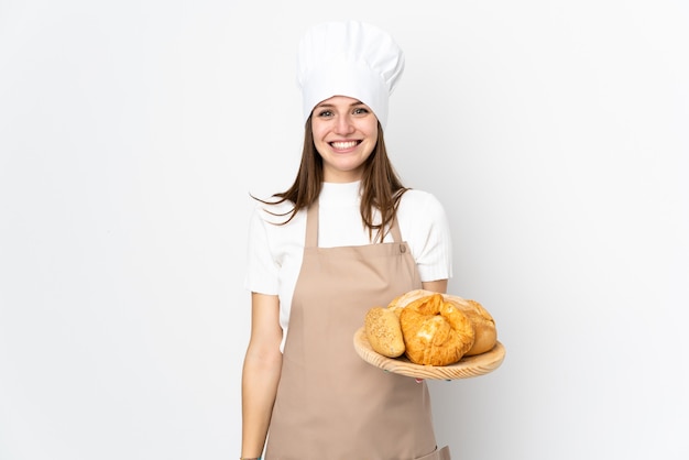 Jeune femme en uniforme de chef sur mur blanc applaudissant