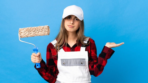 Jeune femme en uniforme avec rouleau de peinture