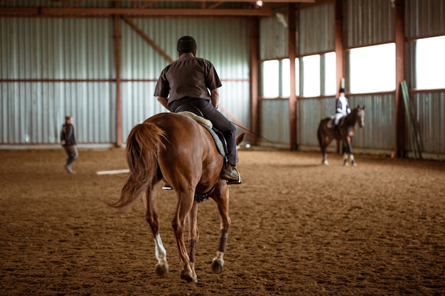 Jeune femme en uniforme spécial et casque à cheval. Sport équestre