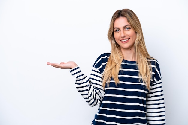 Jeune femme uruguayenne isolée sur fond blanc tenant un fond imaginaire sur la paume pour insérer une annonce