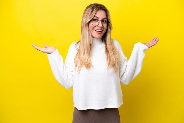 Jeune femme uruguayenne isolée sur fond jaune avec une expression faciale choquée