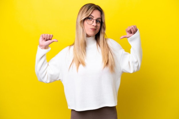 Jeune femme uruguayenne isolée sur fond jaune fière et satisfaite