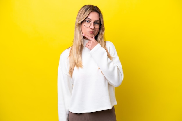 Jeune femme uruguayenne isolée sur fond jaune pensant